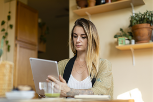 Woman shopping for groceries on her tablet, while working from home